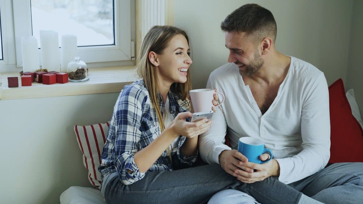 Couple enjoying coffee together and checking in